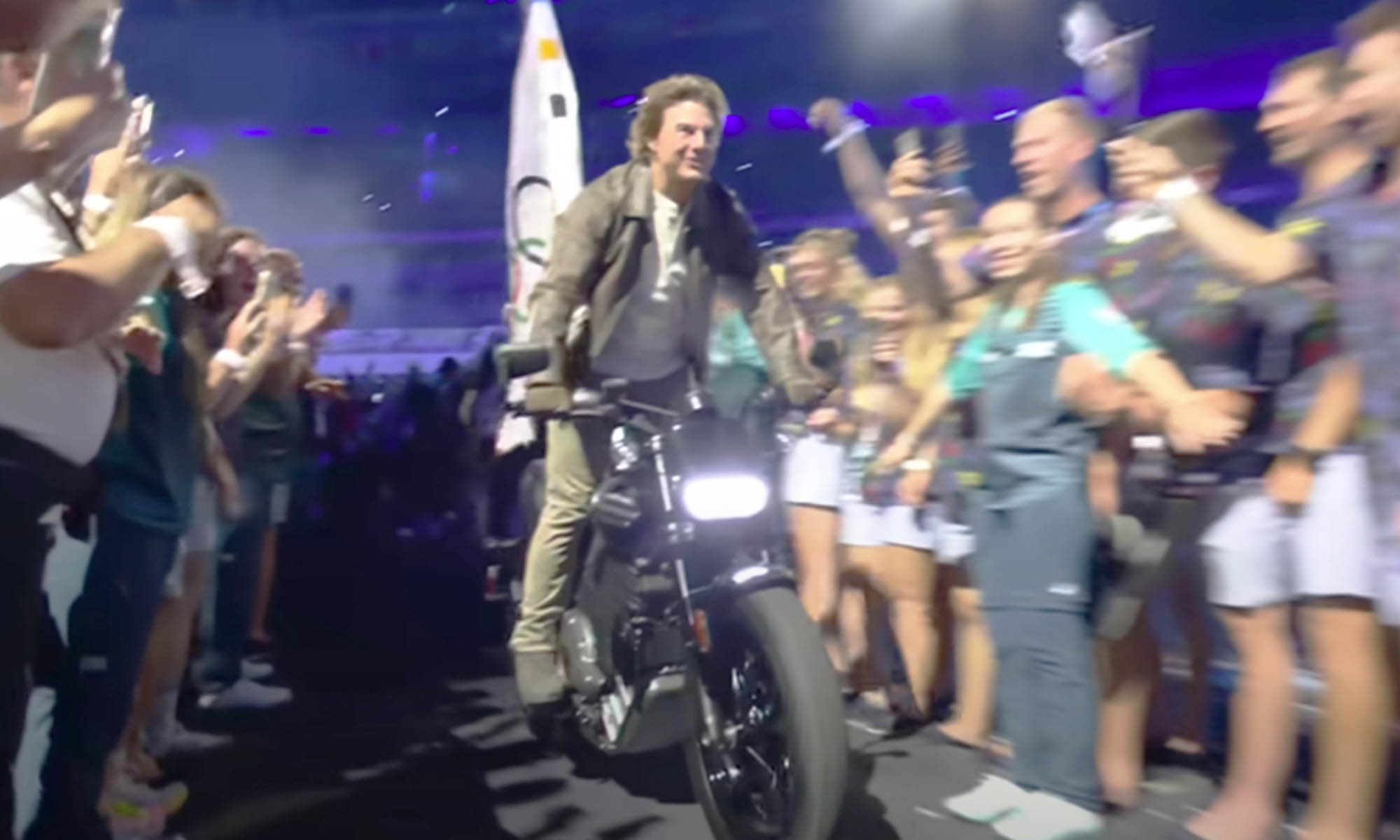 Tom Cruise entre los atletas, llevando la bandera olímpica hacia la ciudad de Los Ángeles.